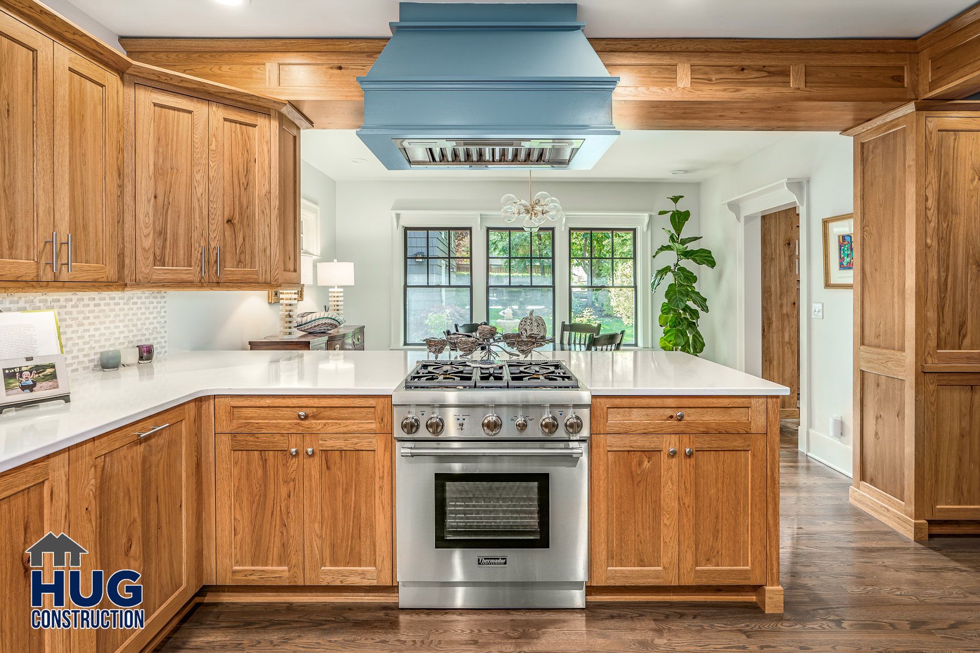 A photo of a kitchen with stove, range hood, and custom cabinetry.