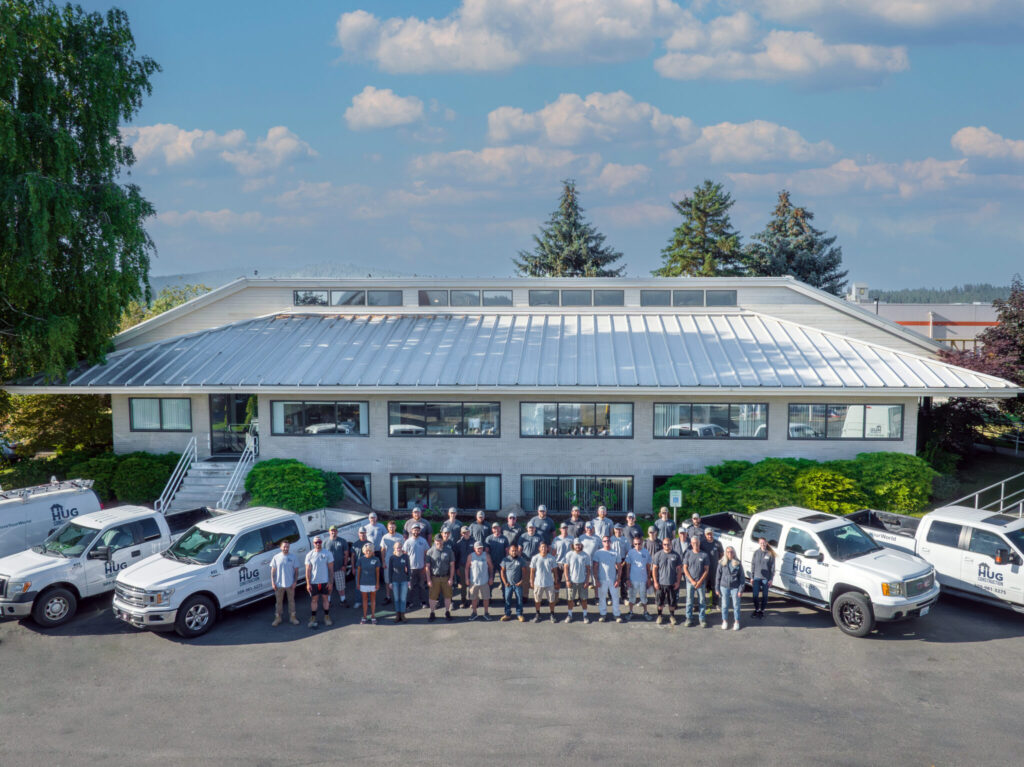 This is a photo with the Hug Construction employees standing in front of their headquarters in Spokane Valley.