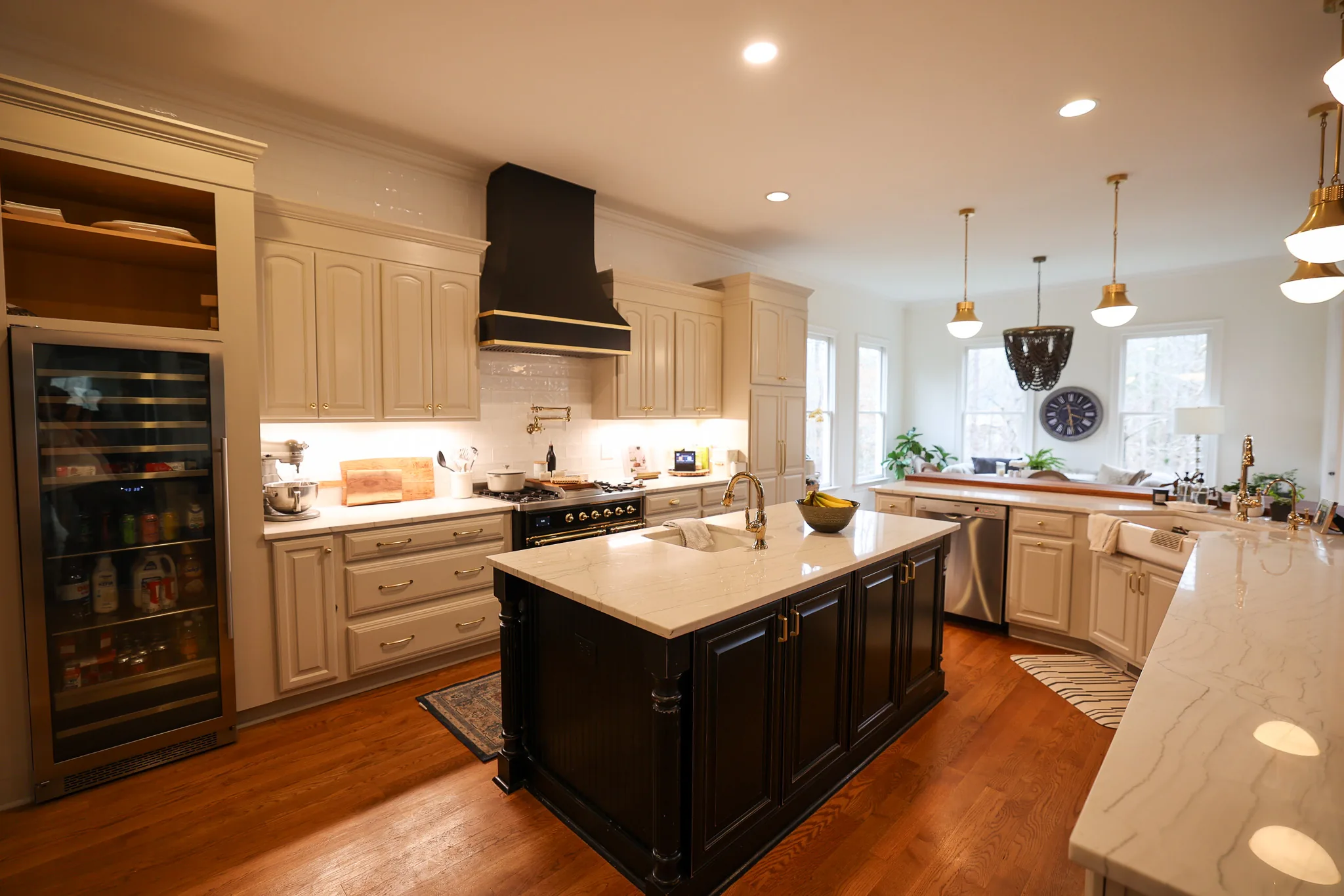 Remodeled kitchen with a black range hood, dark island, and built-in wine refrigerator