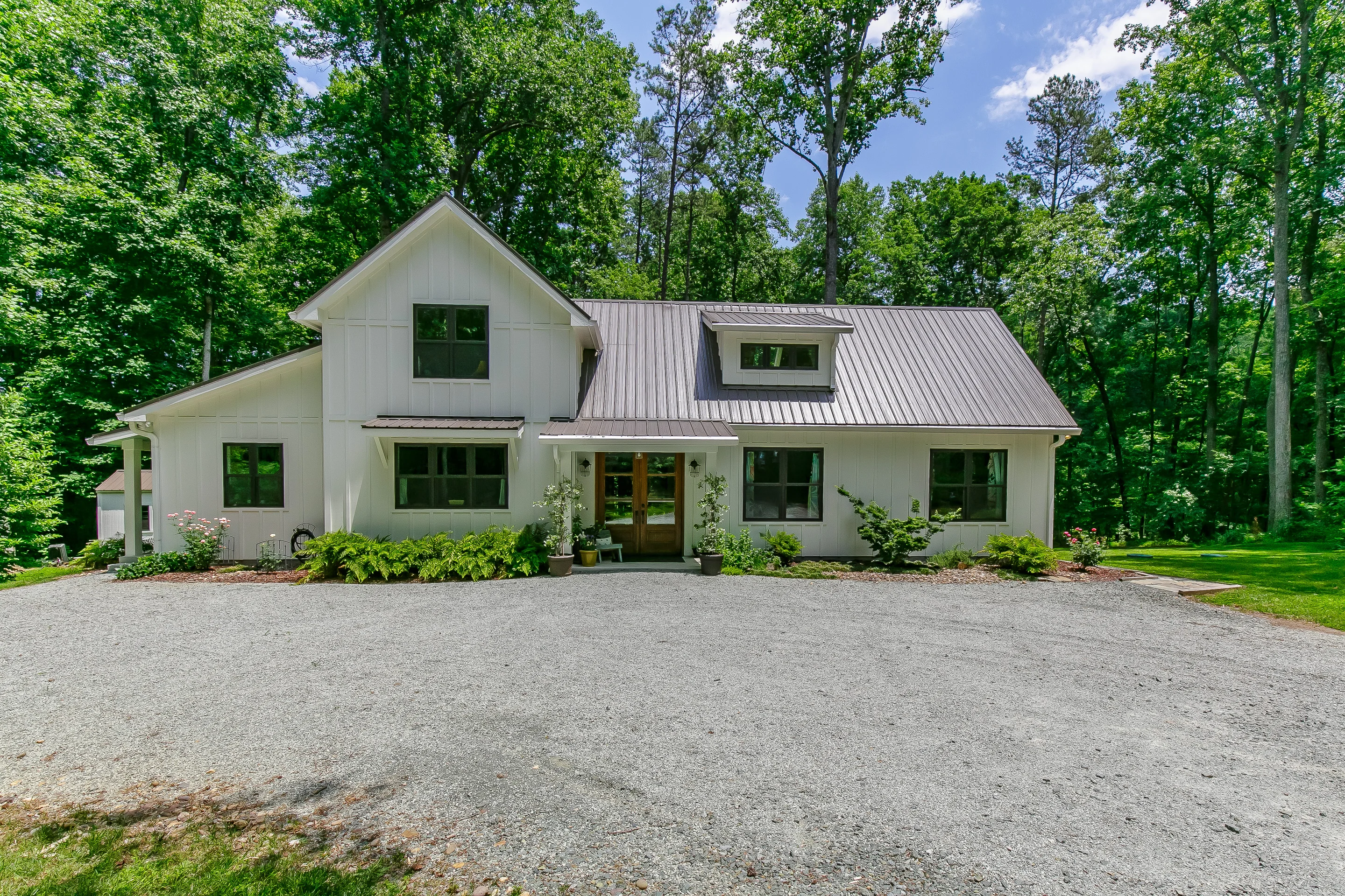 Front exterior of the Flowering Dogwood custom home in a wooded setting