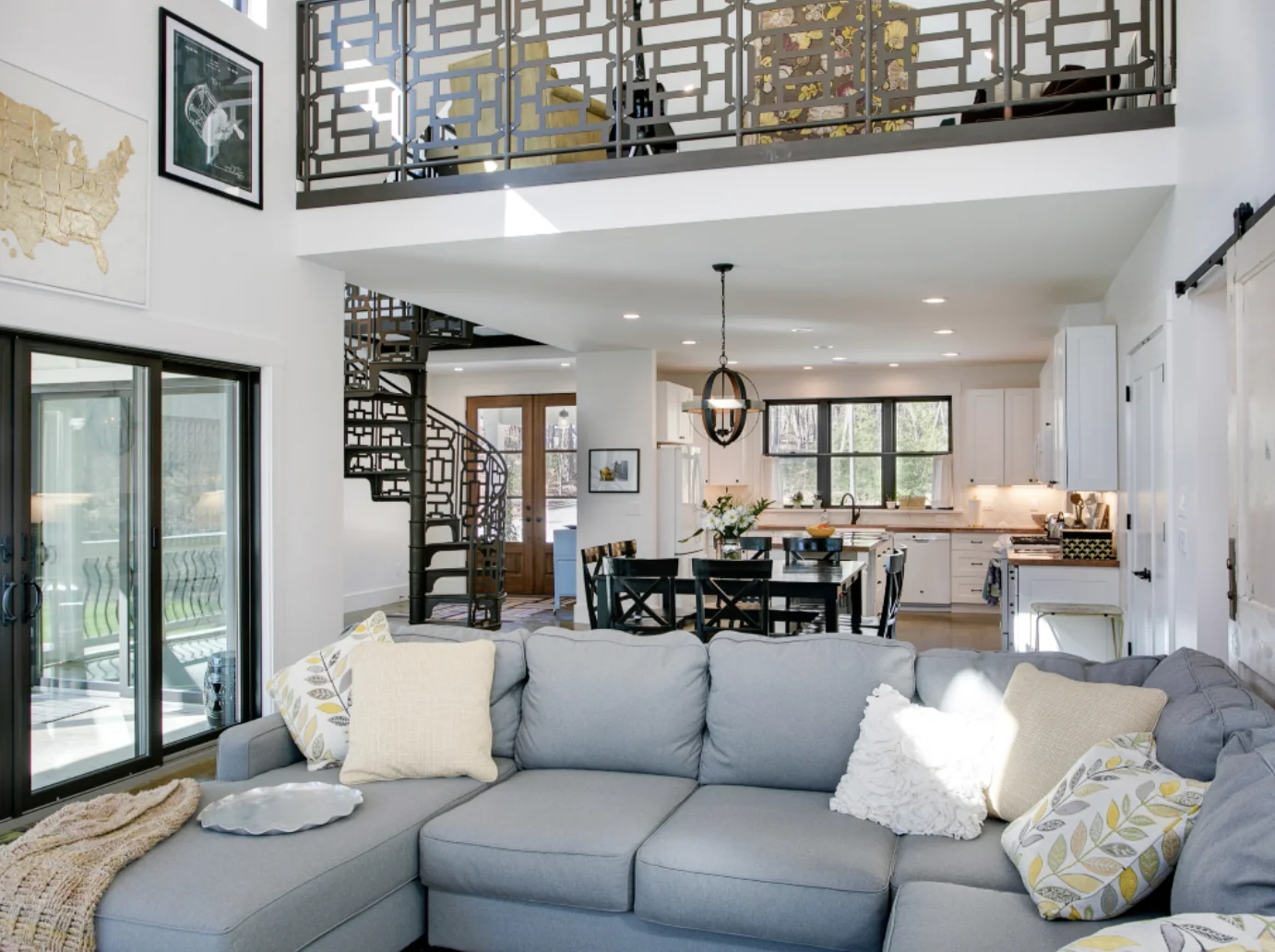 Open living room, dining area, and kitchen with custom metal loft railing