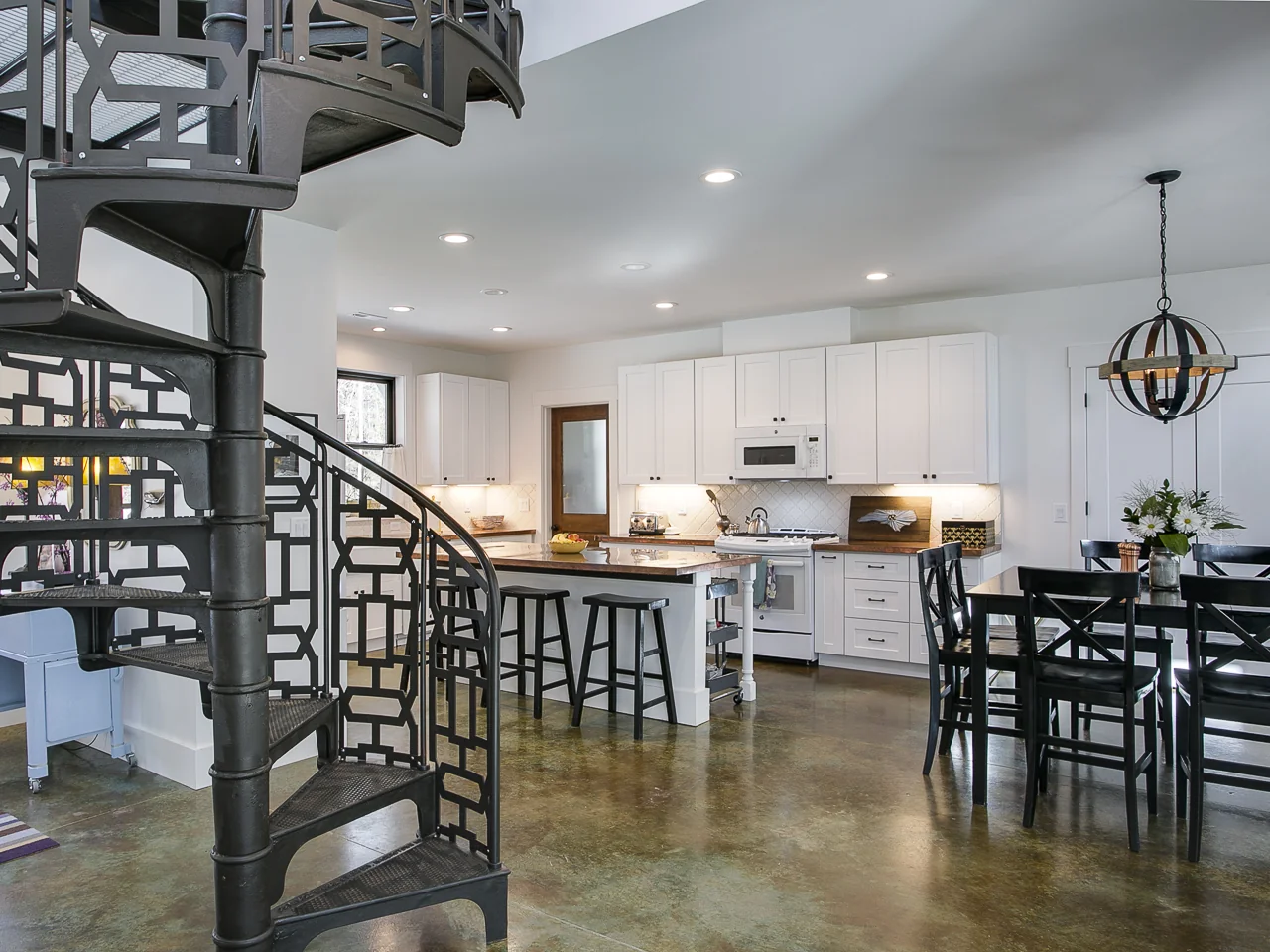 Spiral staircase beside the open kitchen and dining area
