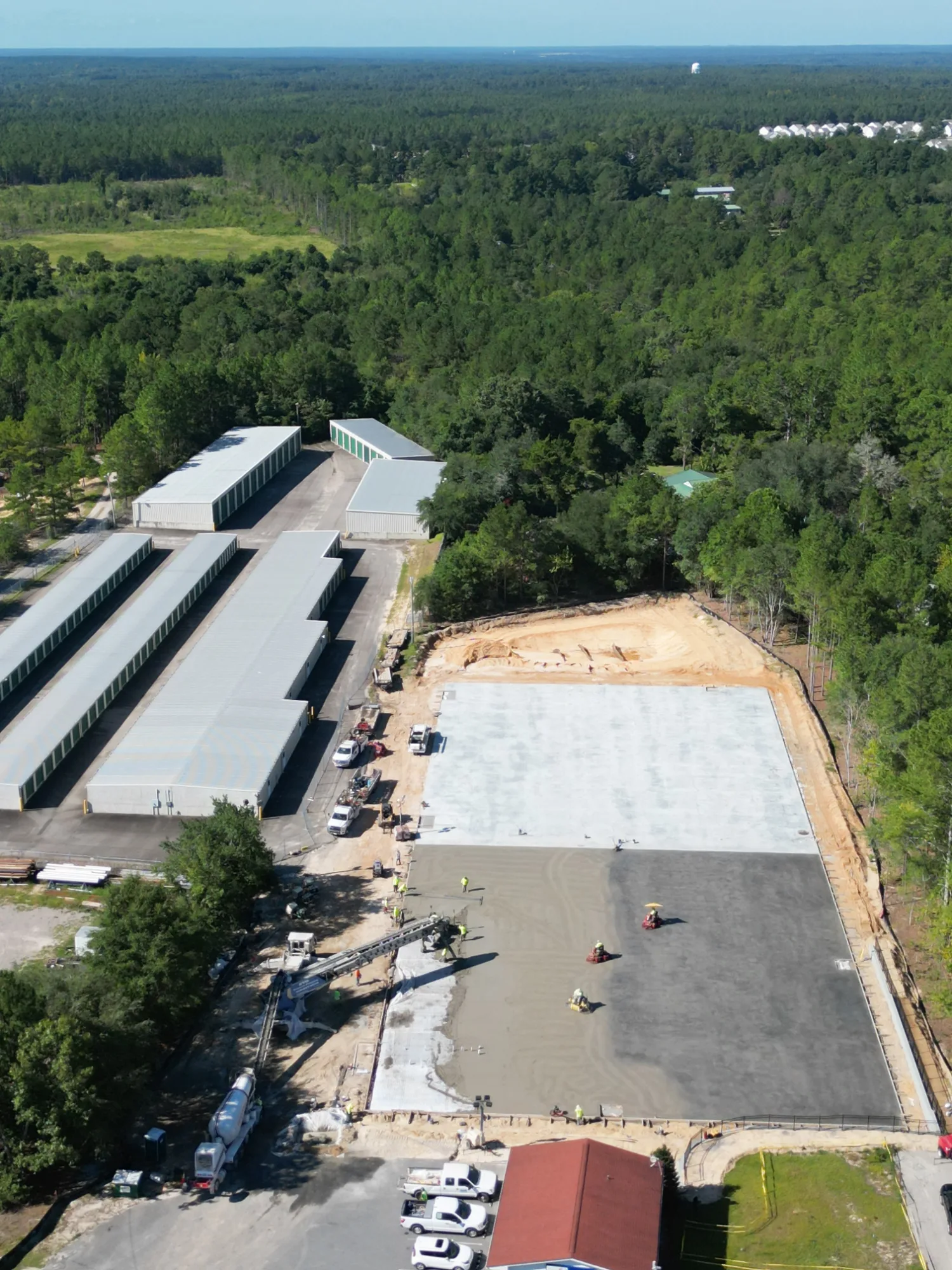 Aerial view of the Aberdeen, North Carolina self-storage expansion with a newly poured concrete building pad beside existing storage buildings