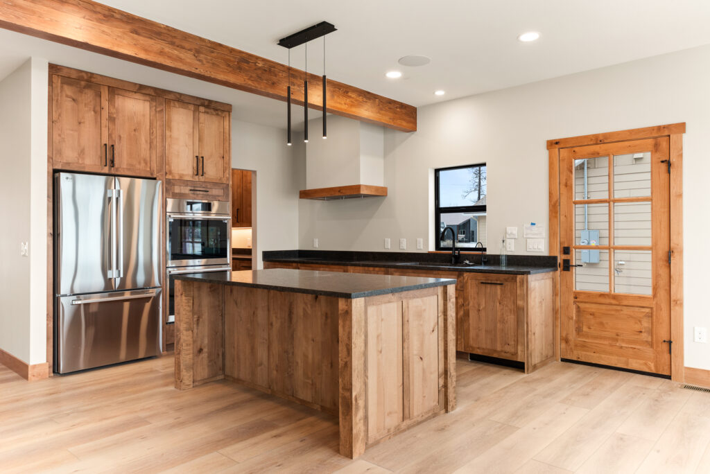 Alderwood. Interior photo of the kitchen and island with appliances.