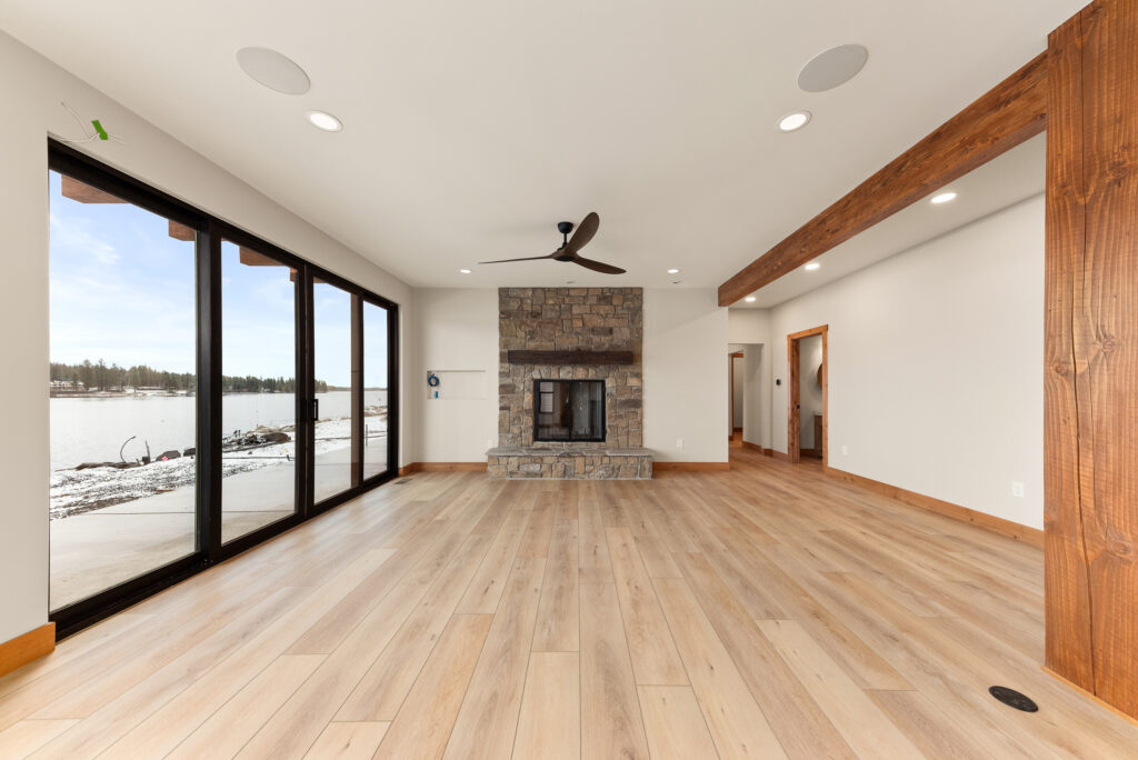 Alderwood. Interior photo of the fireplace and large wall of windows.