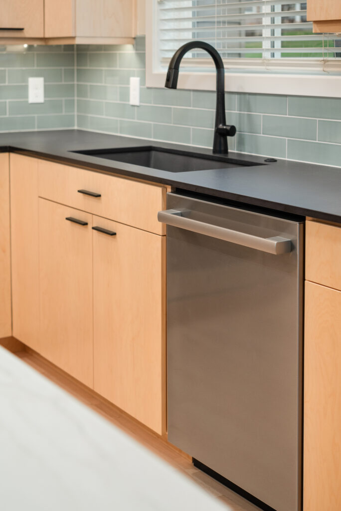 Interior image of kitchen sink, countertop, and dishwasher.