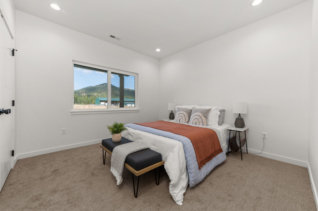 Interior shot of a bed in a bedroom.